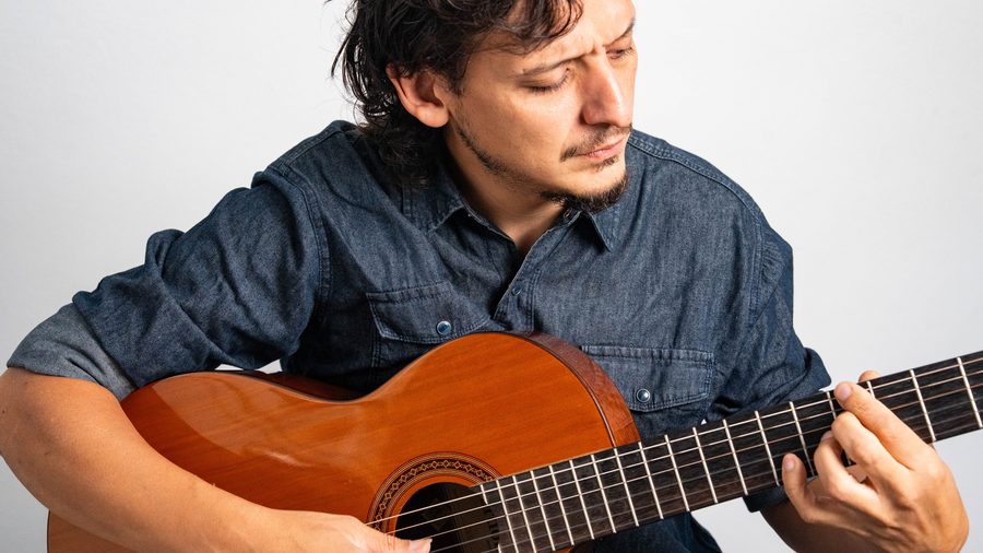 Juan Nieva tocando guitarra concentrado